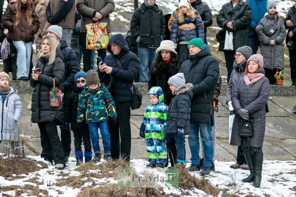 Люди стоять на вулиці взимку під час події