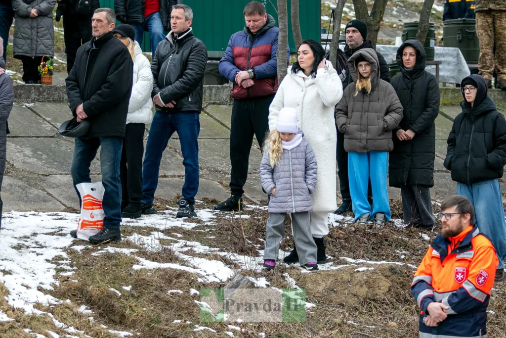 Люди стоять на вулиці під час зимового заходу