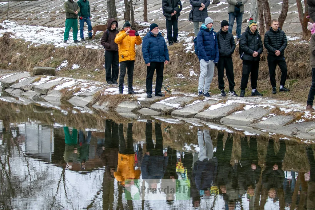 Люди стоять біля зимової річки