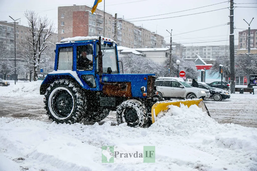Трактор прибирає сніг на міській вулиці