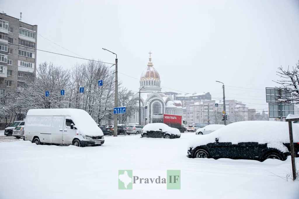 Засніжене місто з автомобілями та церквою