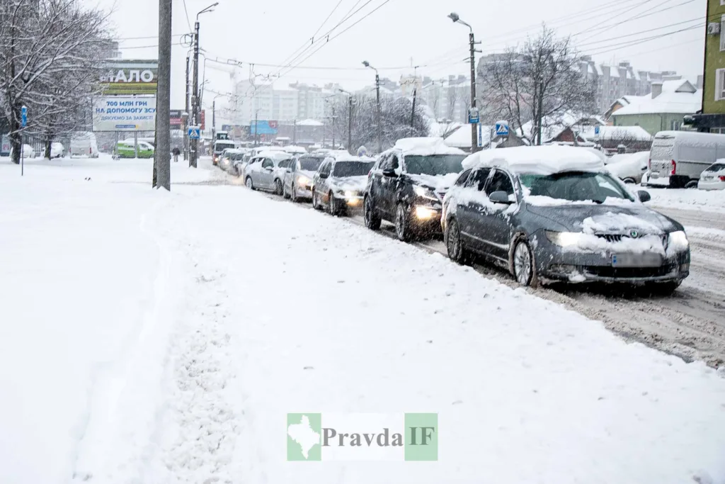 Автомобілі в заторі на засніженій міській вулиці