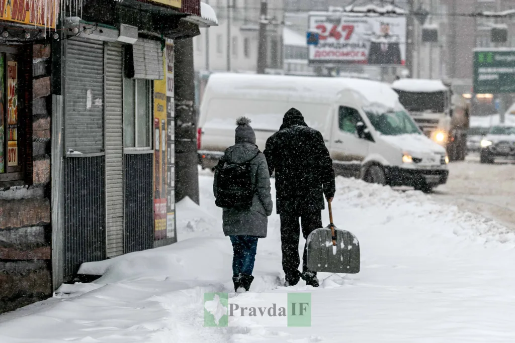 Люди йдуть засніженою вулицею взимку