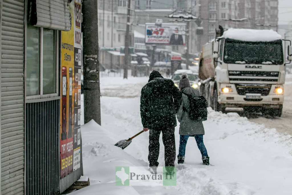 Люди йдуть засніженою міською вулицею взимку