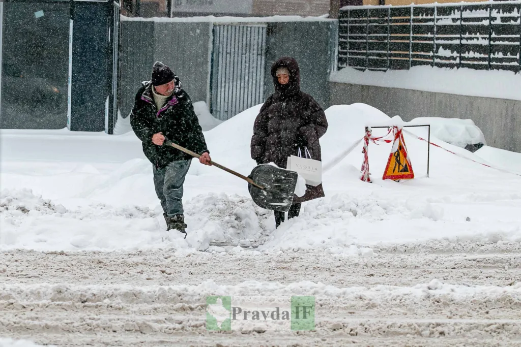 Люди розчищають сніг на засніженій міській вулиці