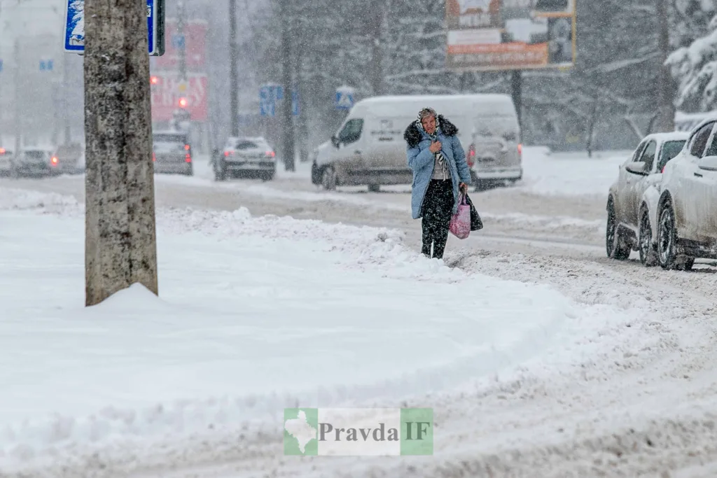 Жінка йде сніжною вулицею під час хуртовини
