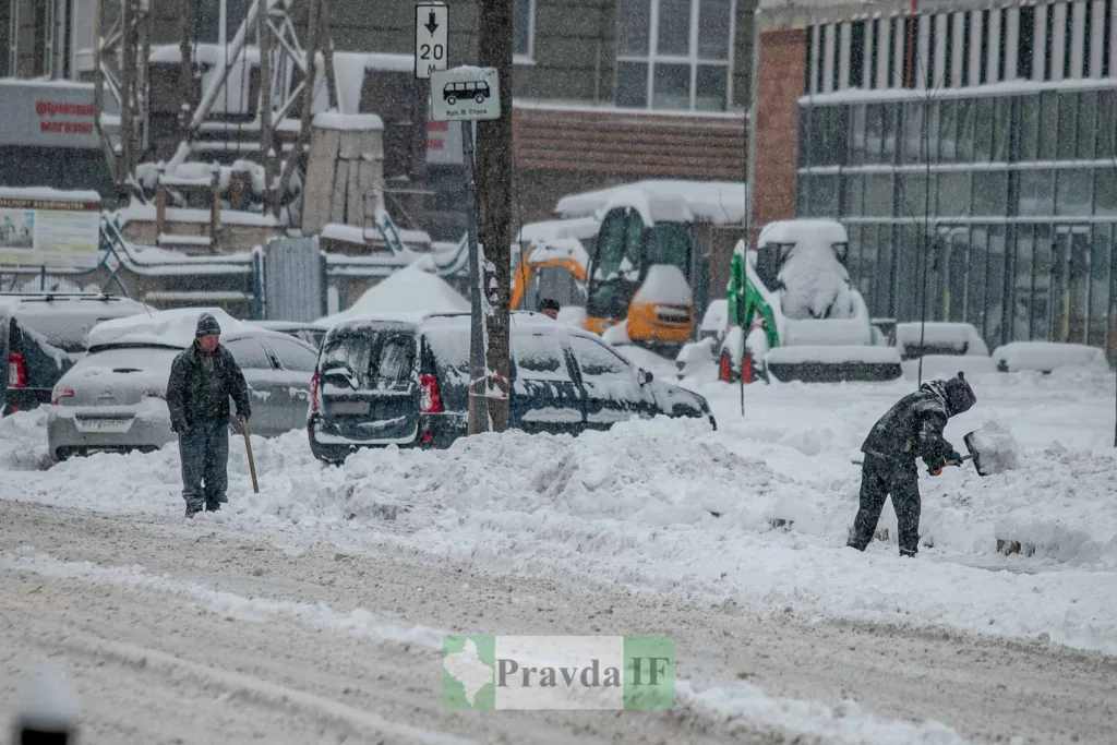 Люди прибирають сніг на зимовій вулиці