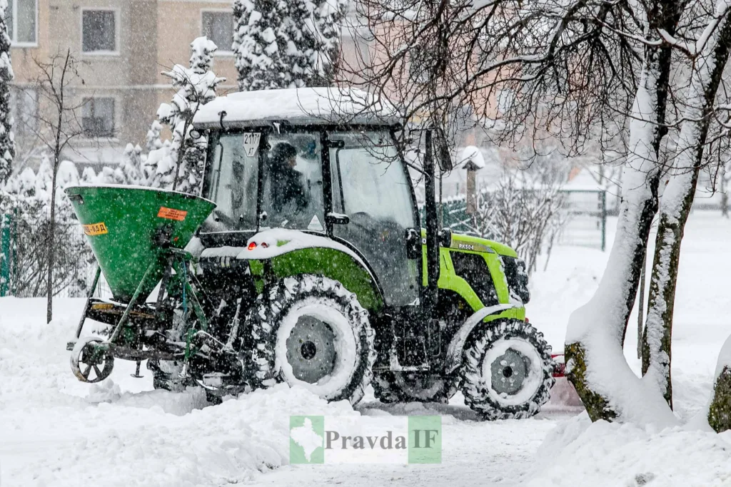 Трактор розчищає сніг на міській вулиці