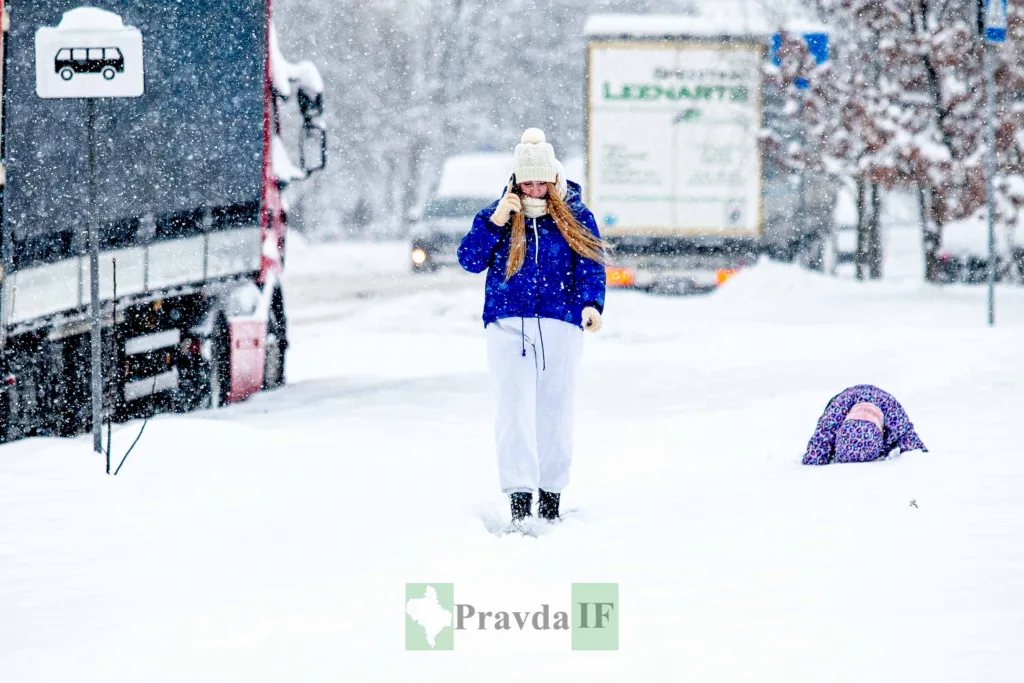 Люди йдуть снігом біля зупинки взимку