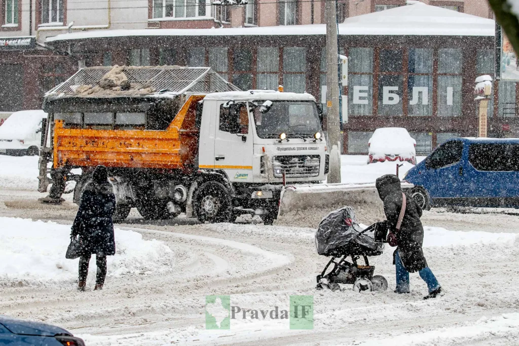 Снігопад у місті, люди переходять дорогу