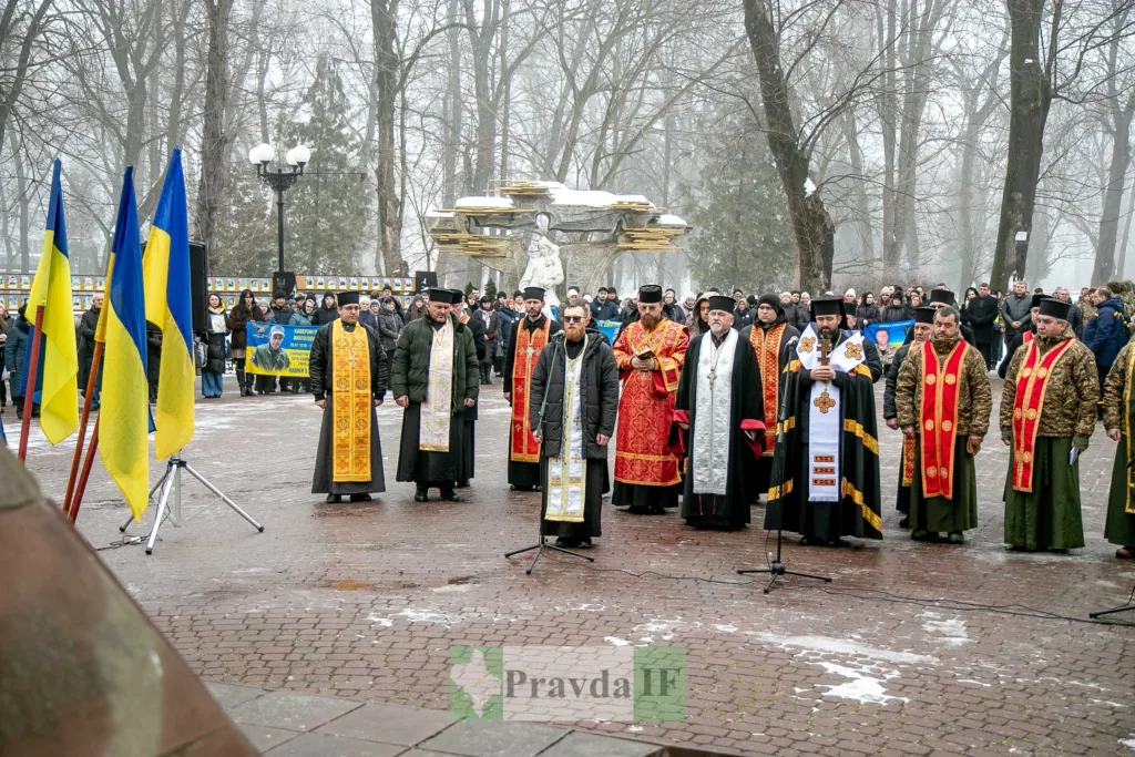 Молитва священників у парку з українськими прапорами