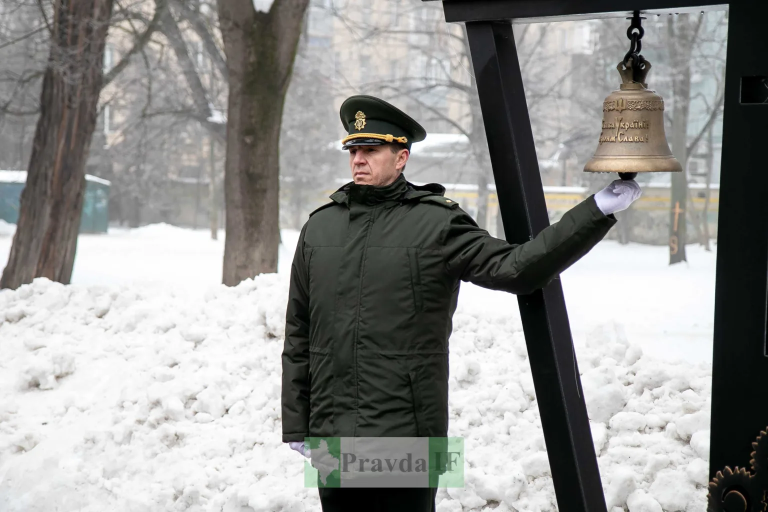 Військовий дзвонить у дзвін на снігу