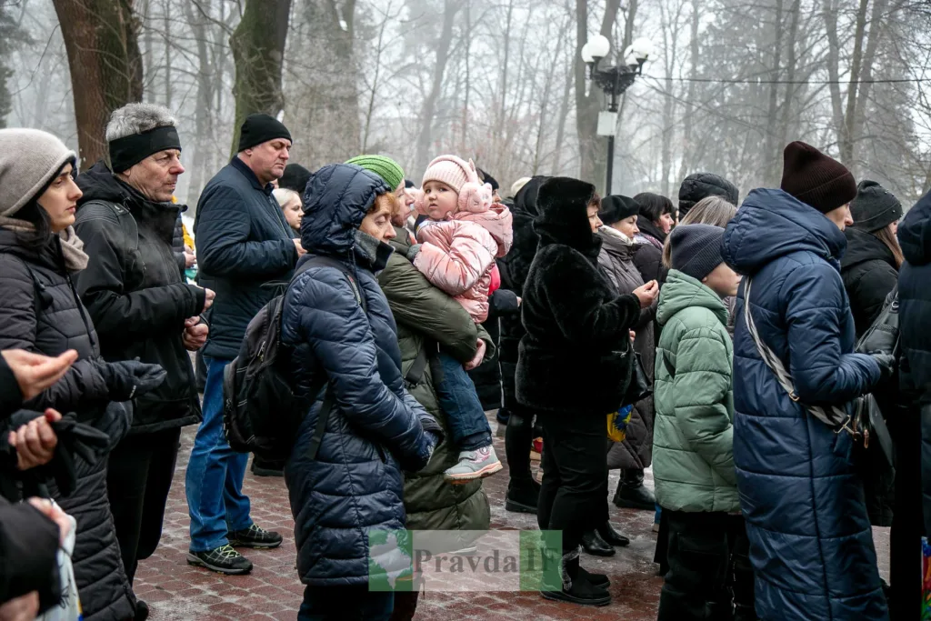 Люди стоять на вулиці в зимовому одязі
