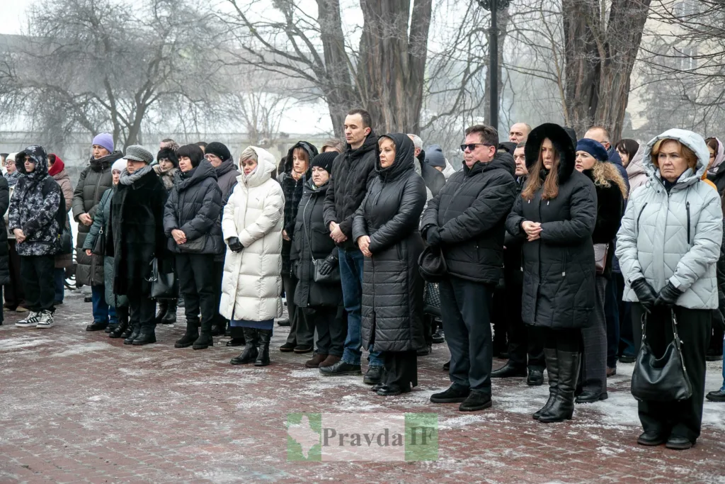 Люди стоять на вулиці під час зібрання взимку