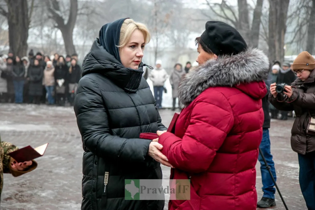 Жінки обмінюються нагородою під час зимової церемонії