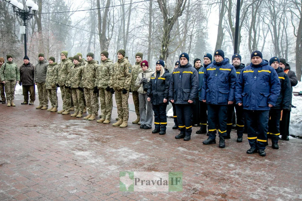 Військові та рятувальники стоять на вулиці взимку