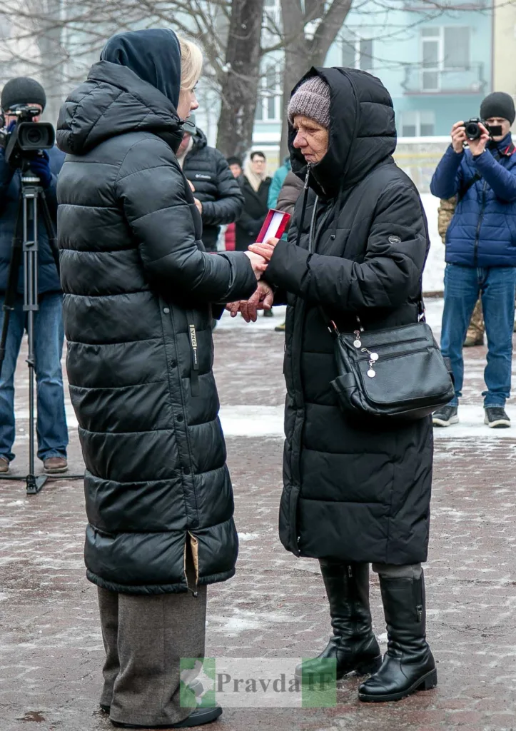 Жінки обмінюються медаллю на вулиці взимку