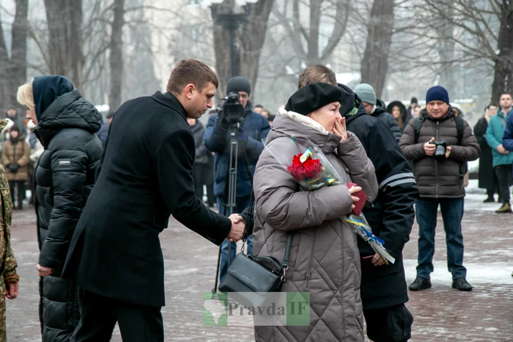 Люди на вуличній церемонії пам’яті взимку