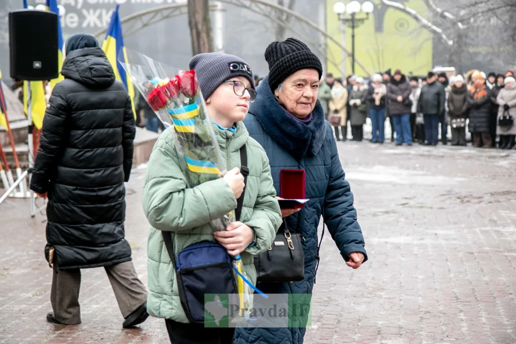 Люди з квітами на вуличній церемонії в Україні