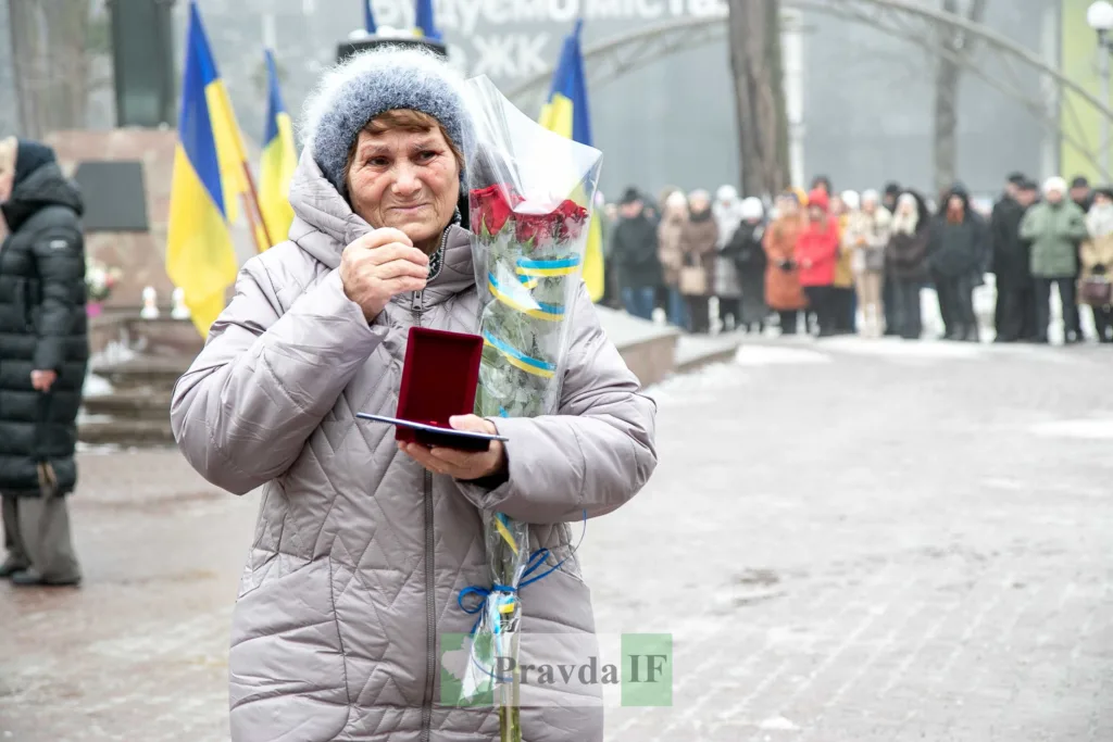 Жінка з квітами отримує нагороду на церемонії