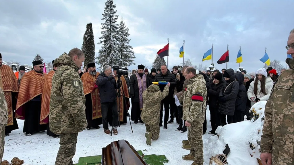 Військові та люди на похороні під снігом