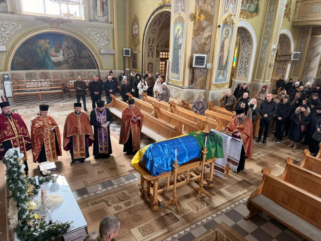 Похоронна служба в церкві з труною під прапором