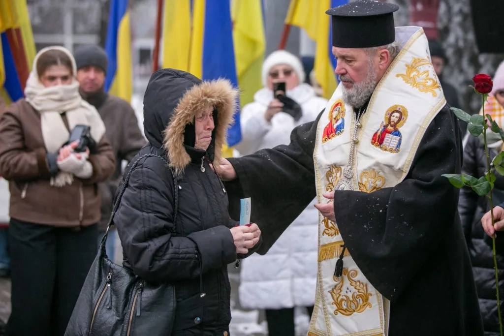 Священник втішає жінку під час вуличної церемонії