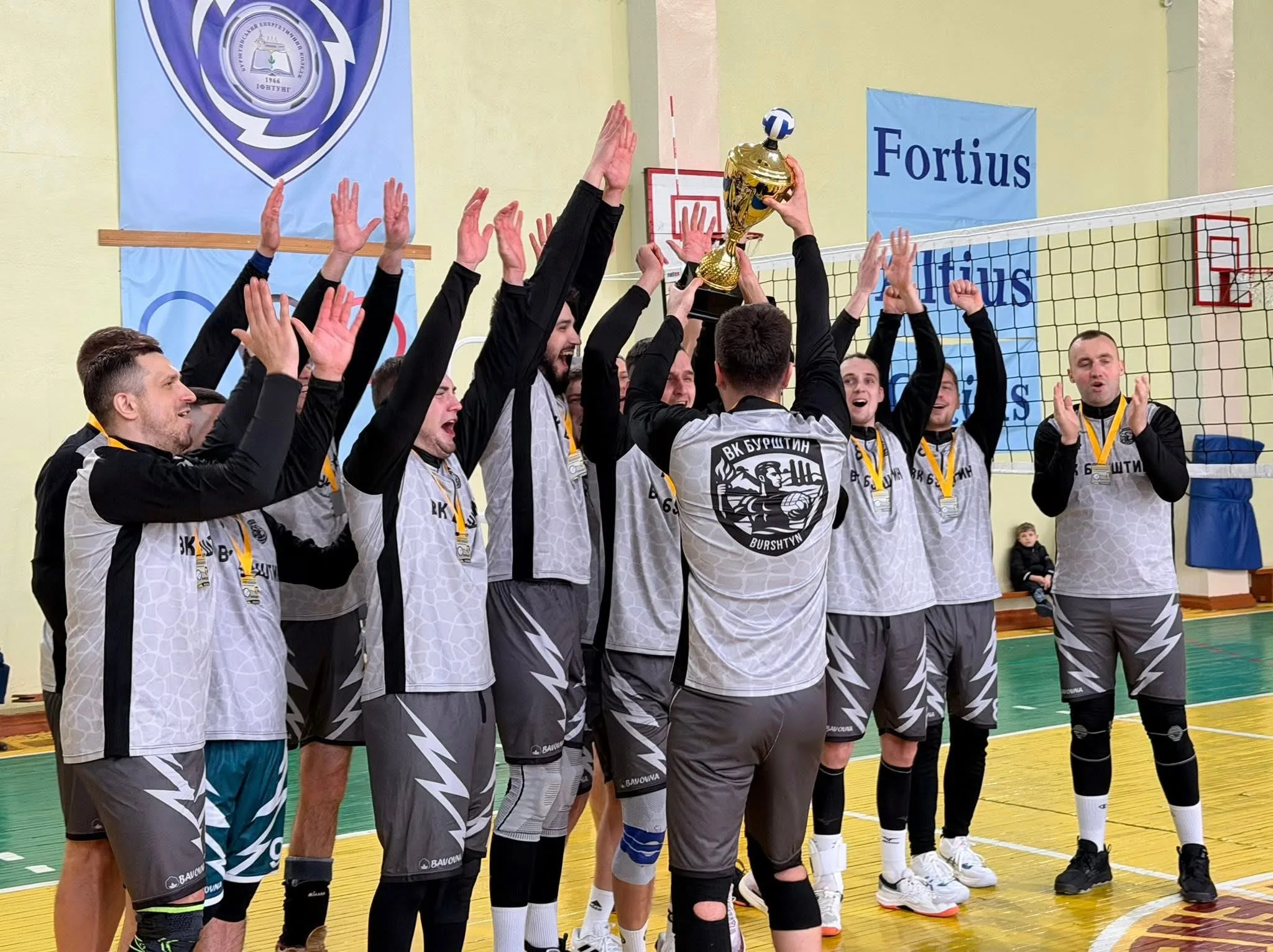 Волейбольна команда святкує перемогу з кубком