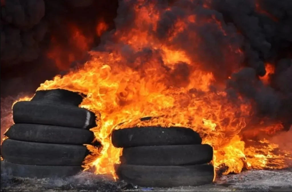 Палаючі автомобільні шини у вогні та диму