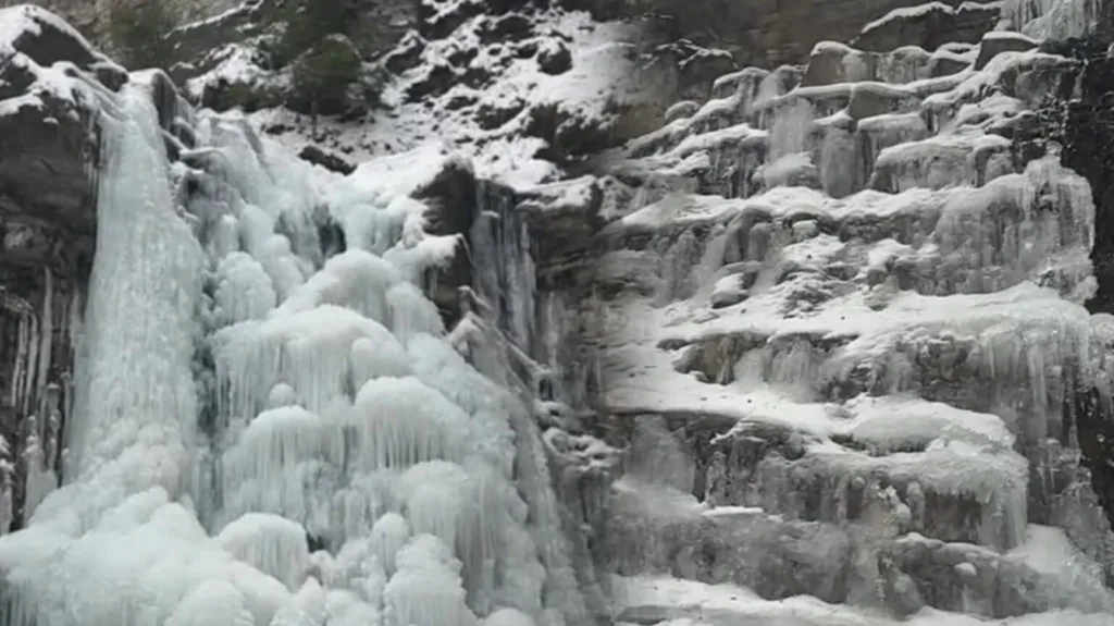 Замерзлий водоспад у засніжених горах