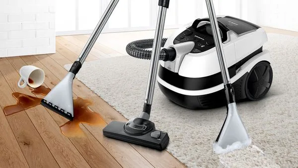 Пилосос прибирає пролиту каву з підлоги