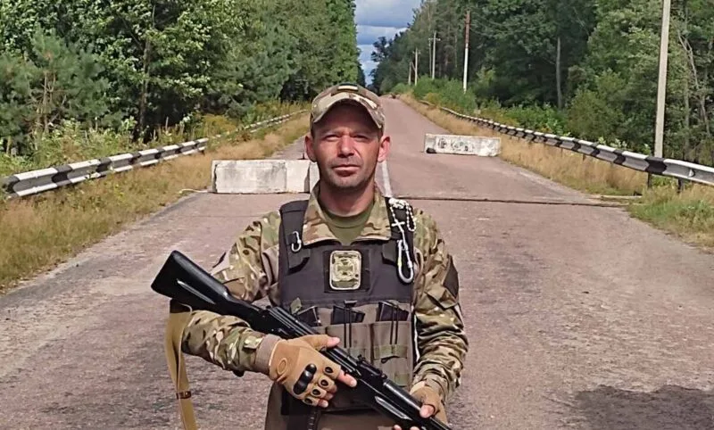 Військовий стоїть на дорозі з гвинтівкою