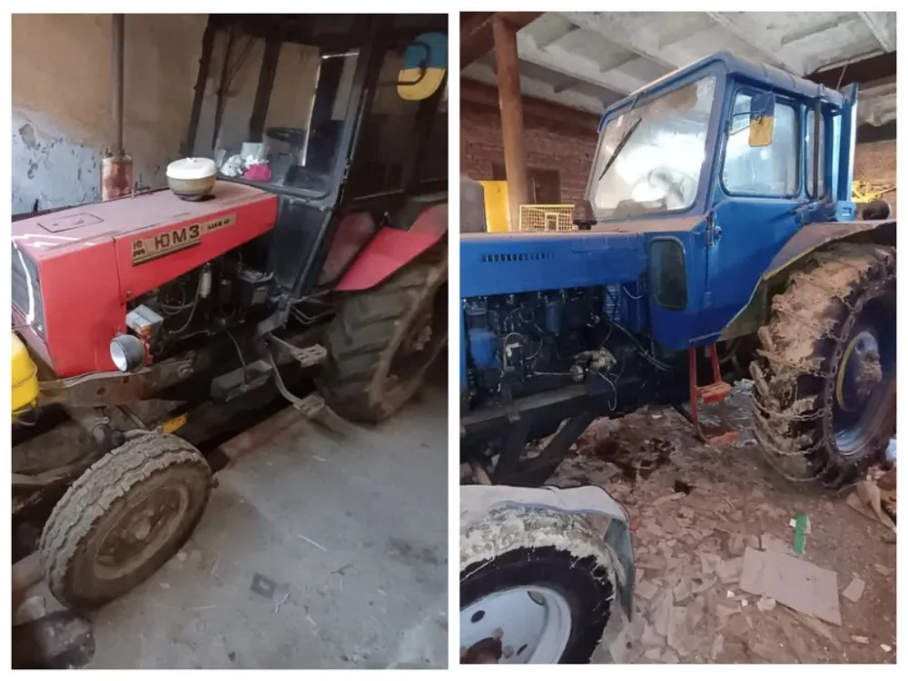 Червоний і синій трактори в гаражі