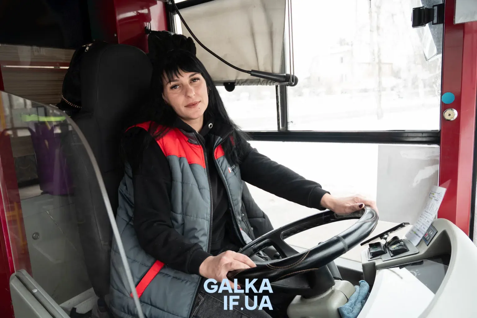 Водійка автобуса сидить за кермом транспорту