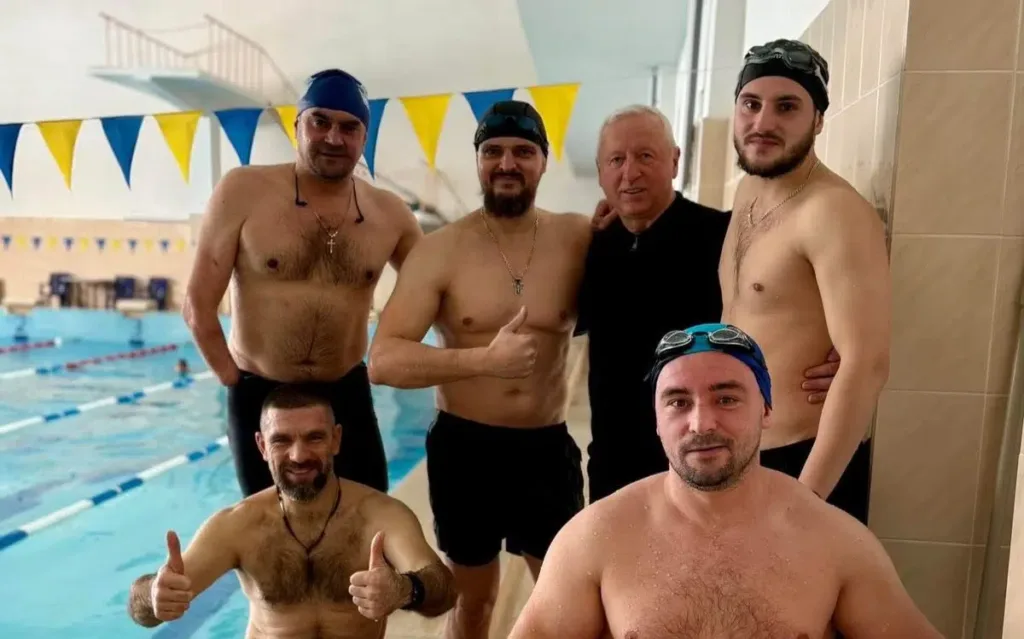 Плавці позують біля басейну після тренування