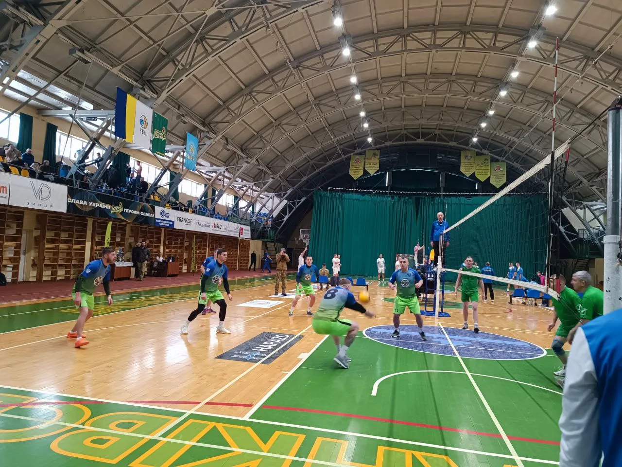 Чоловіки грають у волейбол у спортивному залі