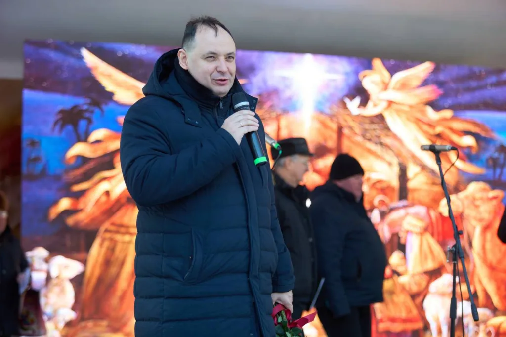 Чоловік виступає на різдвяному святі з мікрофоном