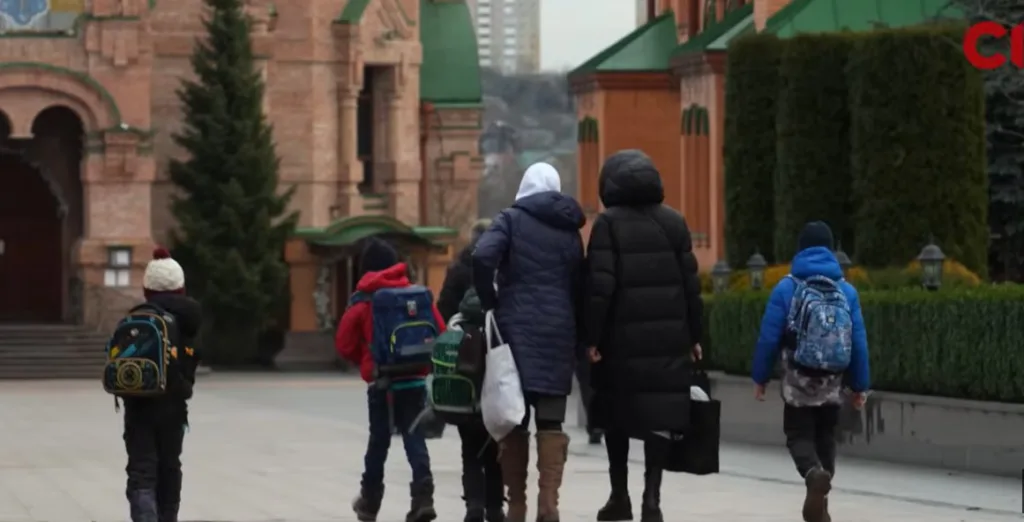 Діти та дорослі йдуть біля церкви