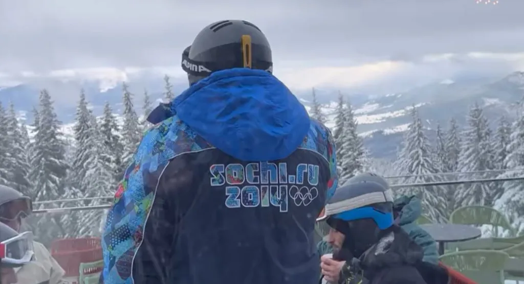 Лижники на засніженій горі з видом на ліс