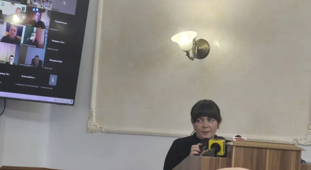 Жінка виступає на конференції з онлайн-учасниками