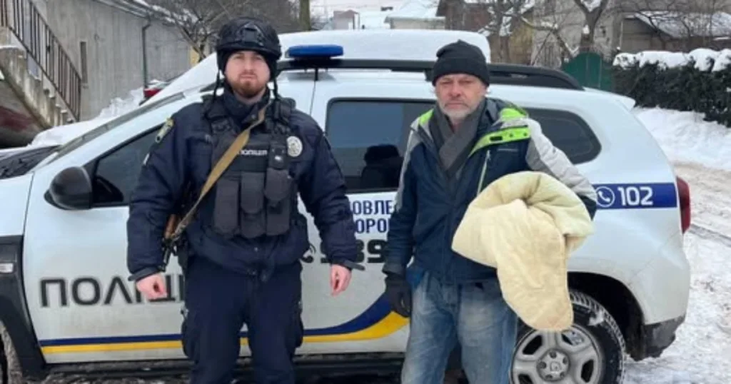 Поліцейський допомагає чоловіку біля патрульного автомобіля