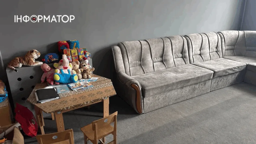 Дитячий куточок із іграшками та сірим диваном