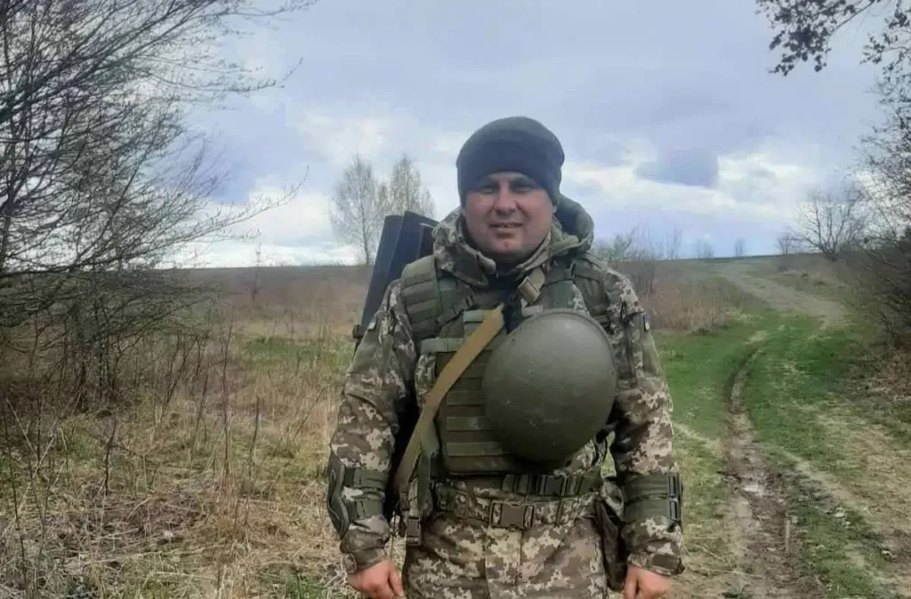 Український військовий у полі в камуфляжі