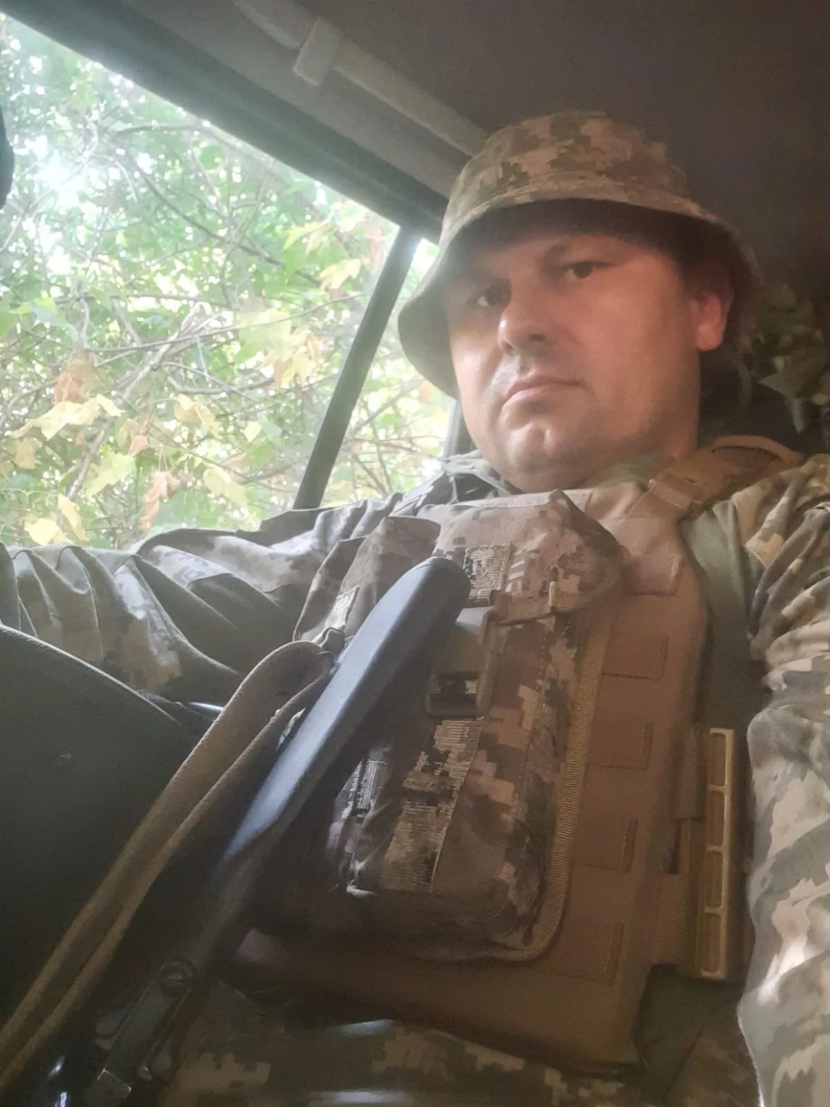 Військовий у камуфляжі сидить у транспорті