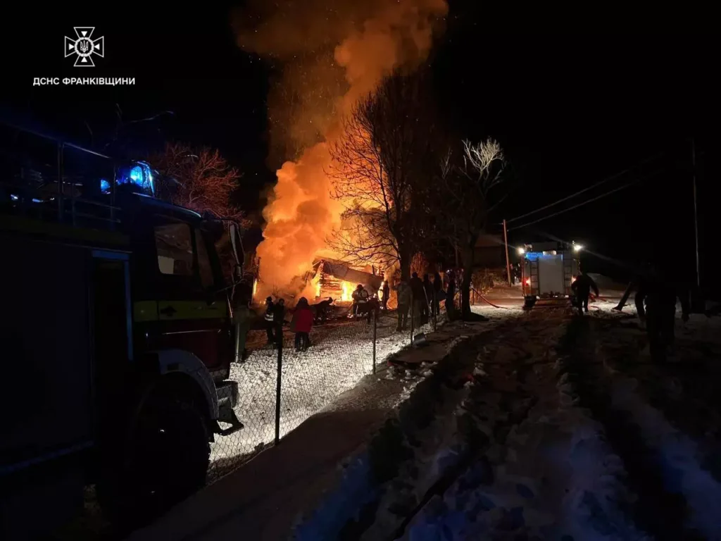 Пожежники гасять будинок, що горить уночі