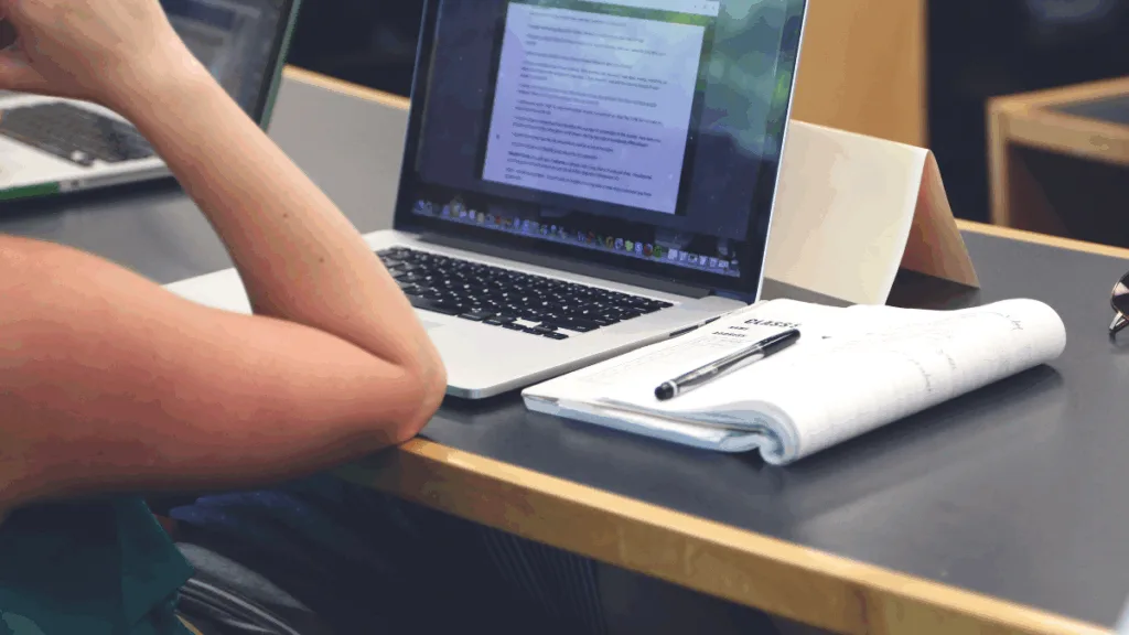 Студент навчається за ноутбуком у бібліотеці