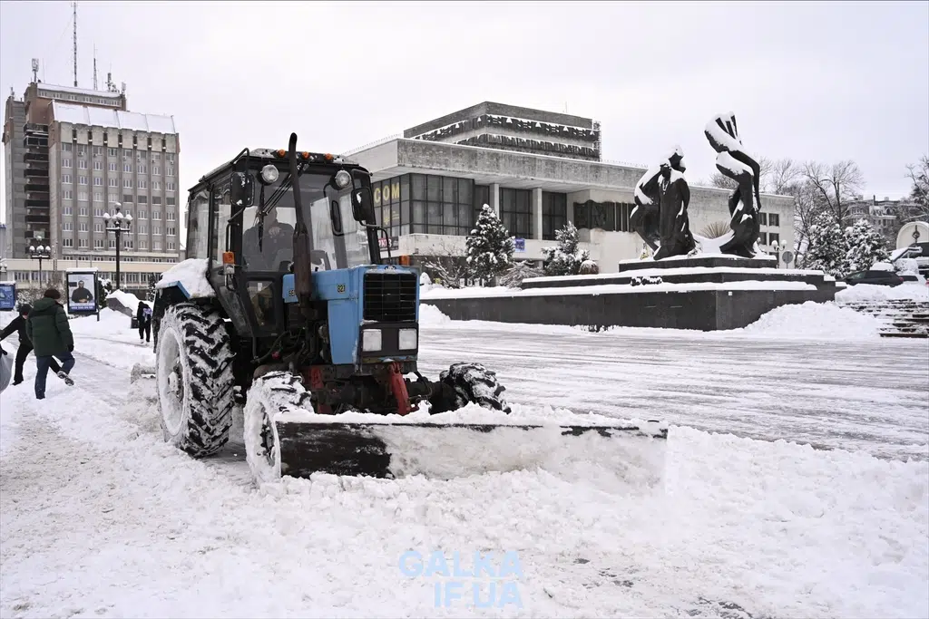 Трактор розчищає сніг у місті взимку