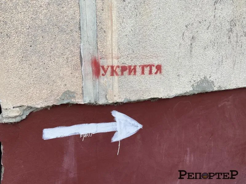 Напис укриття та стрілка напрямку на стіні