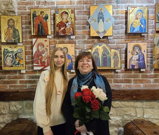 Дві жінки перед іконами у галереї