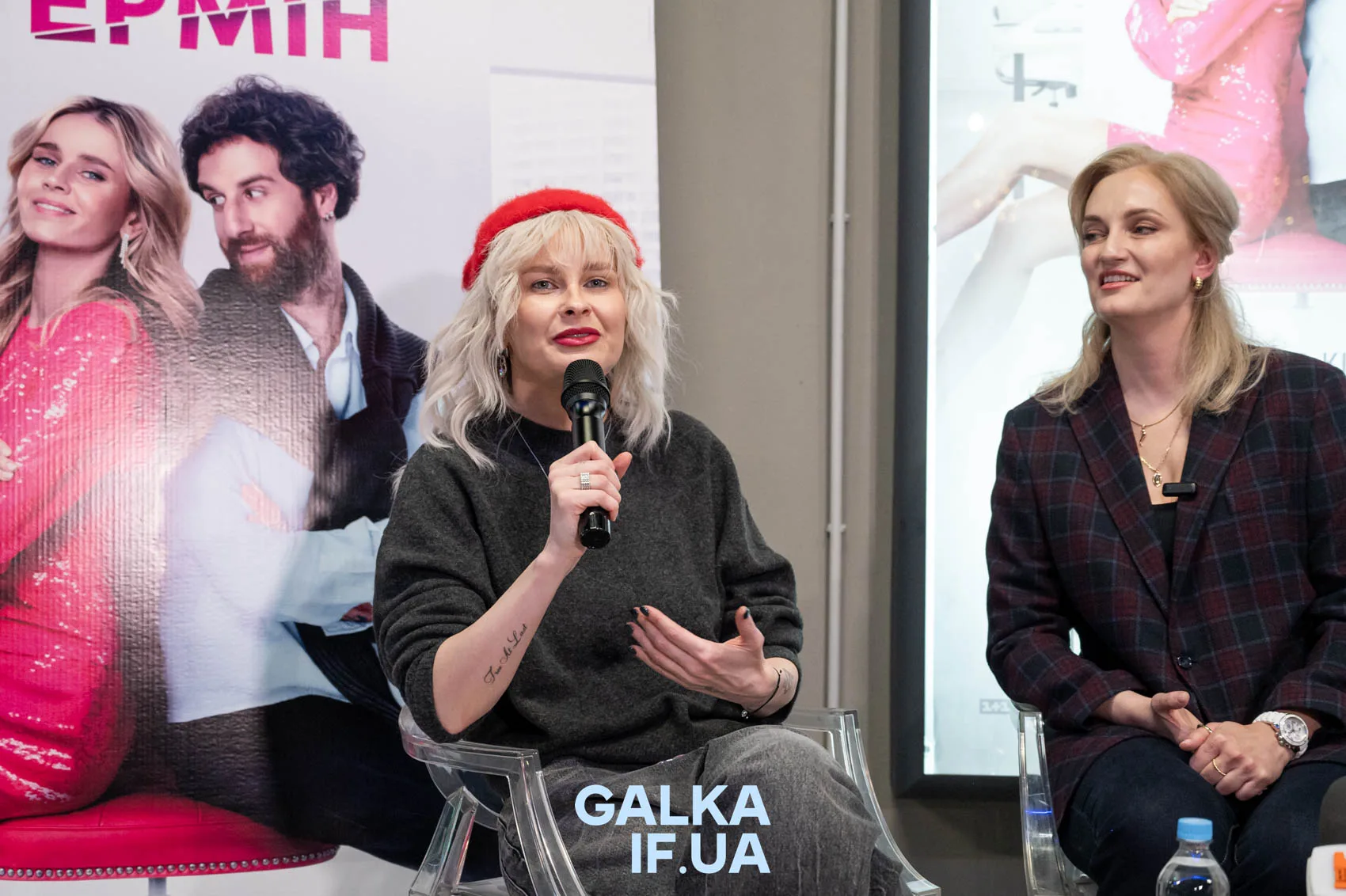 Жінки говорять на пресконференції перед постером фільму